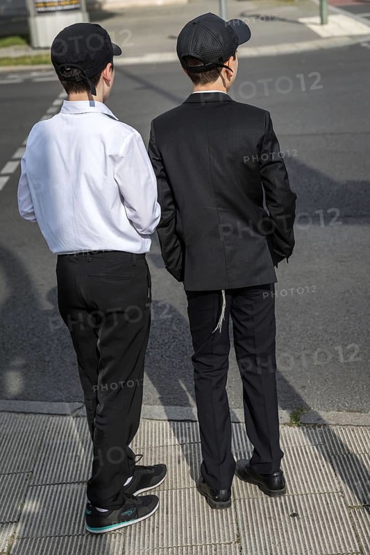 DEU Germany Germany Berlin Two boys in suits with baseball caps at a pedestrian crossing