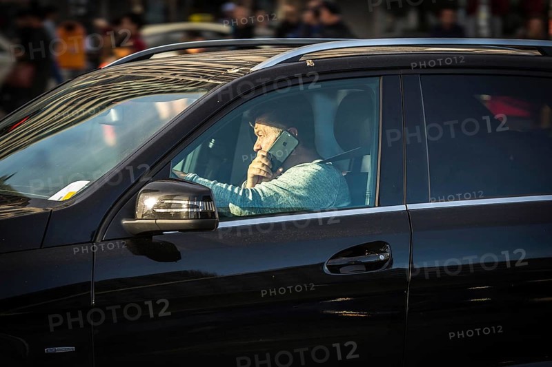 DEU Germany Germany Berlin A man talks on the phone while driving his SUV across Potsdamer Platz