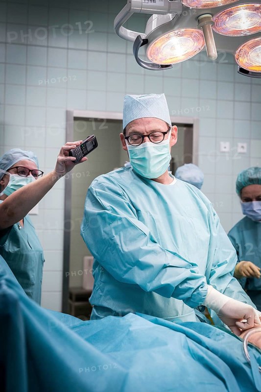 DEU Germany Germany Wittenberg Everyday life at the Paul Gerhardt Stift Protestant hospital in Luther city Wittenberg, an operation situation in which the head physician is talking on a telephone held by an assistant at the same time