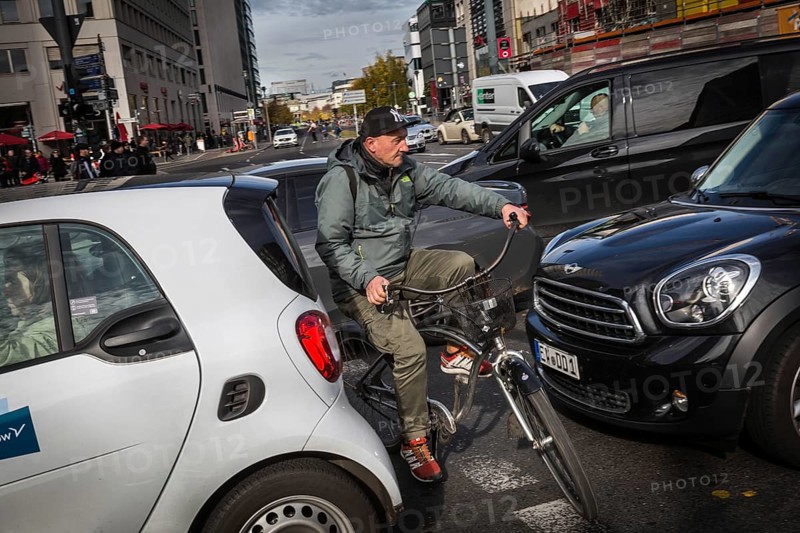 DEU Germany Germany Berlin Cyclists squeeze between stationary cars on Potsdamer Platz