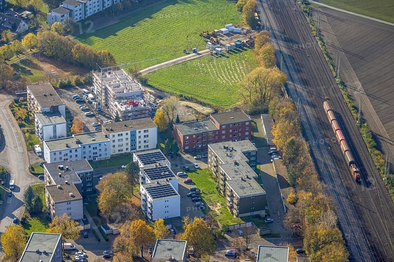 Aerial view, residential buildings construction site Röntgenstraße, Pelkum, Hamm, Ruhr area, North Rhine-Westphalia, Germany, railway tracks, construction work, building, construction area, building site, building plots, construction project, construction site, DE, Europe, shapes and colours, property tax, goods train, high-rise buildings, real estate, aerial view, aerial photography, aerial photography, multi-family houses, new building, photovoltaic, photovoltaic system, solar, solar system, solar energy, solar energy, overview, bird's-eye view, housing estate, housing and living, residential area, residential buildings, housing quality, housing estate, birds-eyes view, overview