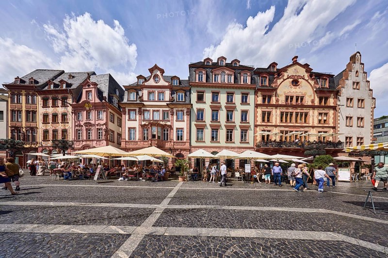 Row of houses, reconstructed historic buildings, outdoor area of a restaurant, Wilma Wunder Mainz restaurant, gastronomy at Markt Mainz GmbH, square made of paving stones and marble tiles with patterns, visitors and pedestrians as secondary motifs, blue sky, cumulus clouds, market square, Mainz, state capital, district-free city, Rhineland-Palatinate, Germany