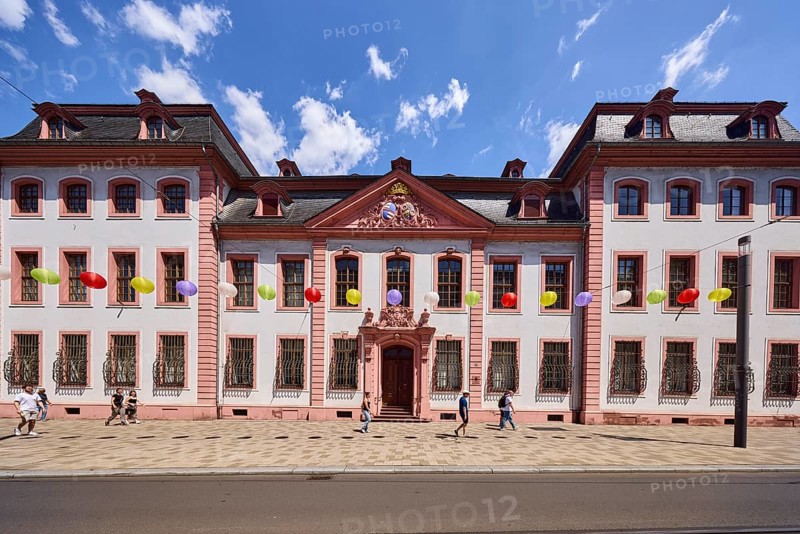 Erthaler Hof, Adelshof, classicism style, façade with windows and door, historic building, lantern, decoration, lanterns, pedestrians as accessories, blue sky, cumulus clouds, street Schillerstraße, Mainz, state capital, district-free city, Rhineland-Palatinate, Germany