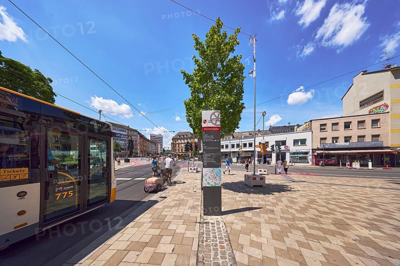 Public bus, public transport, concrete paving walkway, traffic area, street, square, general architecture, commercial building, residential building, tram tracks, bench, tree, bicycle, stele with location sign, cyclists and pedestrians as a secondary motif, blue sky, cumulus clouds, Schillerstraße, Große Bleiche and Münsterplatz intersection, Mainz, state capital, district-free city, Rhineland-Palatinate, Germany