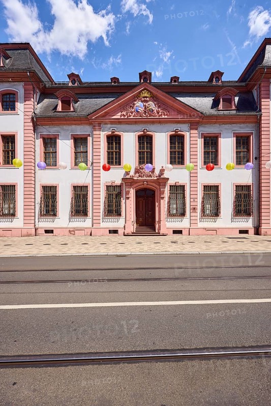Erthaler Hof, Adelshof, architectural style classicism, façade with windows and door, historic building, lantern, tram tracks, asphalt road, decoration, lanterns, pedestrians as accessories, blue sky, cumulus clouds, Schillerstraße street, Mainz, state capital, district-free city, Rhineland-Palatinate, Germany