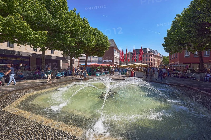 Pedestrian zone, fountain, courtyard fountain, general architecture, shops, retail, weekly market market, pedestrians as a secondary motif, paving stone square, trees common plane tree (Platanus ×hispanica), blue sky, cloudless, Höfchen square, Mainz, state capital, district-free city, Rhineland-Palatinate, Germany