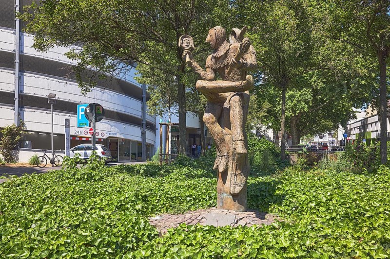 Till Eulenspiegel statue, sculptor Eberhard Linke, Kronberger Hof car park, trees, ground cover, common ivy (Hedera helix), sunny, street Am Kronberger Hof, Mainz, state capital, district-free city, Rhineland-Palatinate, Germany
