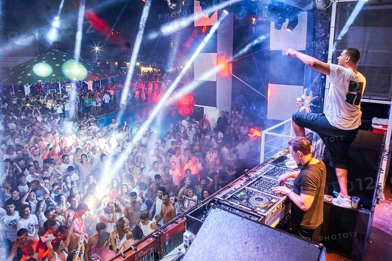 EDITORIAL and NEWS ONLY, rare moment of joint DJ back to back performance of edm dance music DJ Afrojack (on top, the person standing up on DJ pult) performing with DJ Hardwell on DJ pult at Starbeach events festival Hersonissos, Crete, Greece, on 17. July 2017. light show, dance music, crowd, stage performance