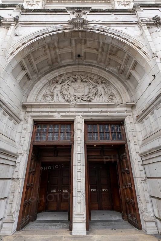 London, United Kingdom - 15 May 2025: Massive carved wooden doors beneath the highly ornate arch of the Victoria and Albert Museum entrance