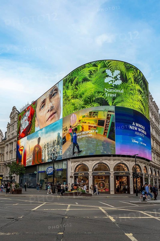 London, United Kingdom - 15 May 2025: A view towards the Electronic billboards in Piccadilly Circus with people outside milling around