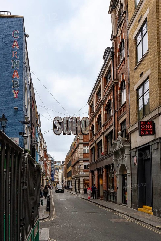 London, United Kingdom - 15 May 2025: The classic London streetscape featuring the iconic soho district hanging sign
