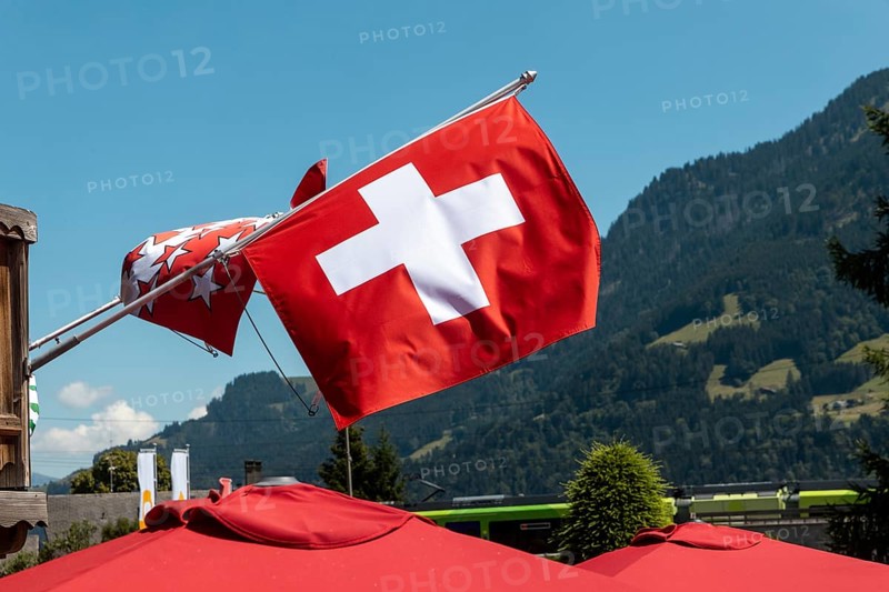 A flag of Switzerland pictured in Champery, a village by the French border with mountains at the background
