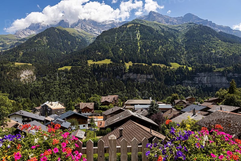 Postcard view of some mountains in Champery with flowers and chalets, in Switzerland
