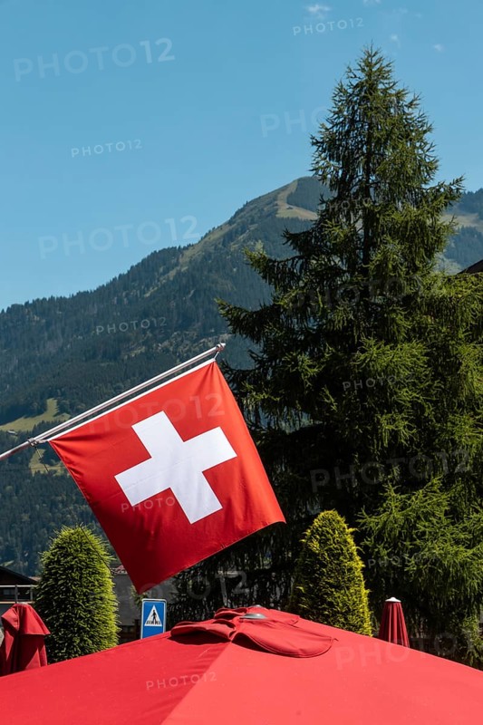 A flag of Switzerland pictured in Champery, a village by the French border with mountains at the background
