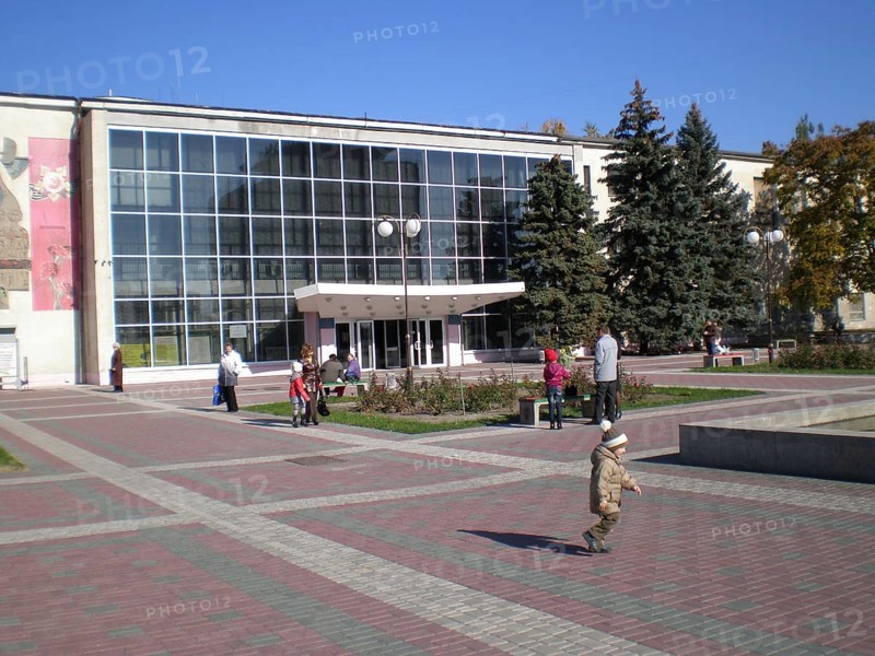 Residents of Melitopol with their children stroll through Victory Square near the Shevchenko Cultural Center. Melitopol, Ukraine