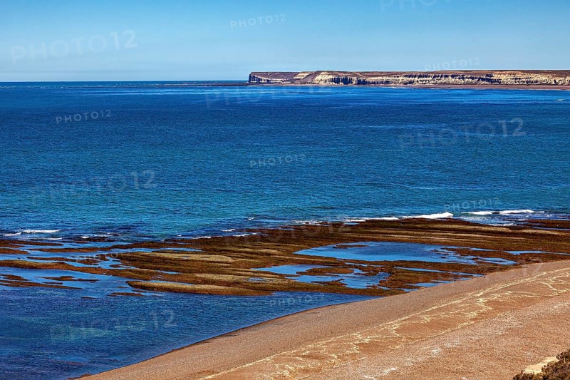 Rocky, cliff-rich coast with deep blue water and clear views, the landscape of Peninsula Valdes in Argentina