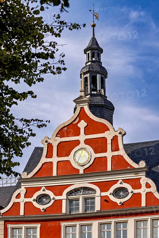 Red building with decorative bell tower, clear sky in the background, historic ambiance, the old town of Arnstadt in Thuringia