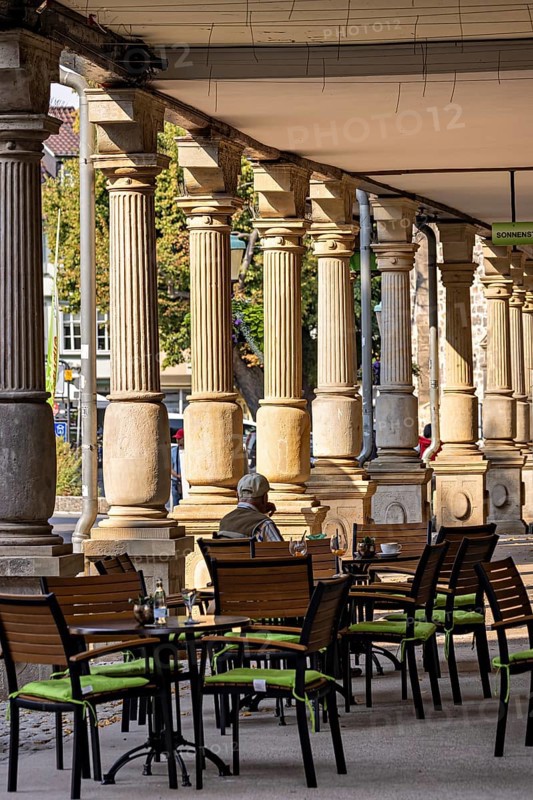 Historic outdoor café under pillars with green chairs and a quiet atmosphere in the city, arcades on the market square of Arnstadt in Thuringia