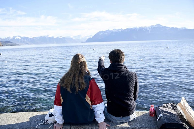 NO MODEL RELEASE, unrecogniseable couple pointing at mountains Les Cornettes de Bise behind Lake Geneva (Genfersee), at lakeside in Lausanna, Kanton Waadt, Switzerland, Europe, daytrip, travel holiday destinations, calm, view of mountainrange