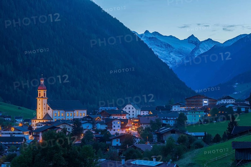 View of town with mountains and Stubai glacier at dusk, Neustift im Stubai Valley, Stubai Valley, Stubai, Tyrol, Austria