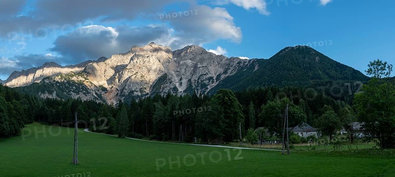 The warm evening sun falls on the steep rock faces of the Kamnik-Savinjer Alps near Zgornje Jezersko, Slovenia