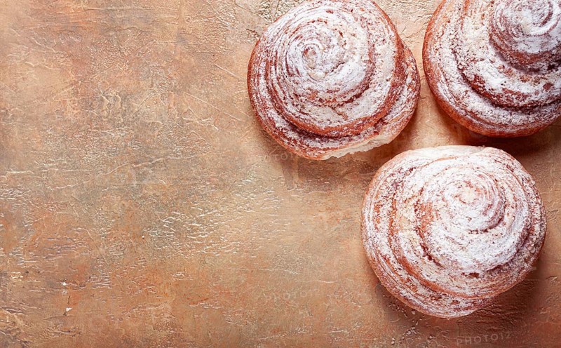 Bakery product, lemon twist, with white glaze, sweet bun, muffin, pastries, top view, no people