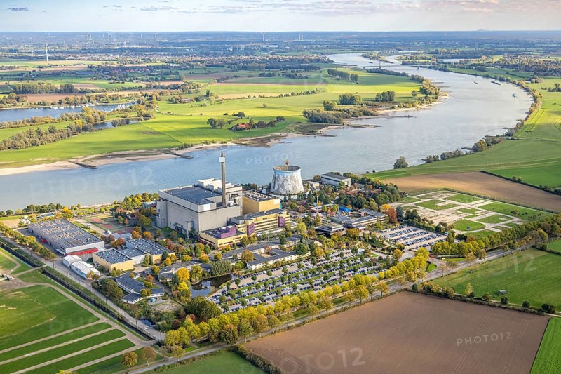 Aerial view, Kalkar Wonderland amusement park on the Rhine river with Rheinaue, Energy Factory, family park with events such as chain carousel in the cooling tower, rollercoaster and wild water ride and rides, hotel, convention center, gastronomy, Hönnepel, Kalkar, Lower Rhine, North Rhine-Westphalia, Germany, adventure, rollercoaster, attractions, excursion destination, visitors, DE, recreation, adults, Europe, rides, family park, river shore, leisure, leisure activities, amusement park, infrastructure, Kalkar Wonderland, children, landscape, aerial photography, aerial photography, travel, Rhine, summer, fun, daylight, theme park, tourism, overview, entertainment, events, bird's eye view, wild water ride, birds-eyes view, overview