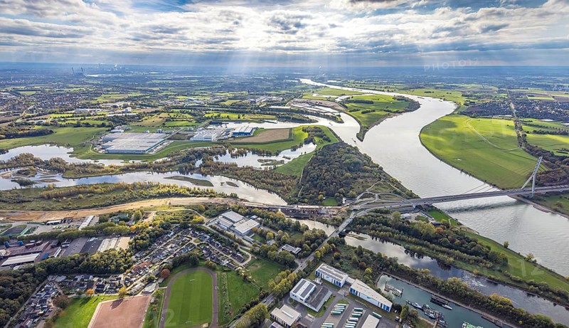 Aerial view, Lippe estuary with construction site, Lippe river and NSG nature reserve, Büdericher Insel, Rhine-Lippe harbour with Rhenus Logistics and Nordfrost GmbH, Rhine river and Wesel Lower Rhine bridge, blue sky with clouds, Wesel, Lower Rhine, North Rhine-Westphalia, Germany, Am Lippeglacis, construction, development, bridge, federal road B8, business, DE, Europe, Lippe river, riverbank, building, commercial area, port, trade, industry, infrastructure, landscape, Lippe estuary, Lippeschlösschen logistics, aerial photography, aerial photography, NSG, nature reserve, Nordfrost GmbH, town view, perspective, Rhine-Lippe-Hafen, Rhenus Logistics, Ruhr area, protected area, urban planning, transport, overview, urban, traffic, traffic connection, bird's eye view, waterway, residential area, birds-eyes view, overview