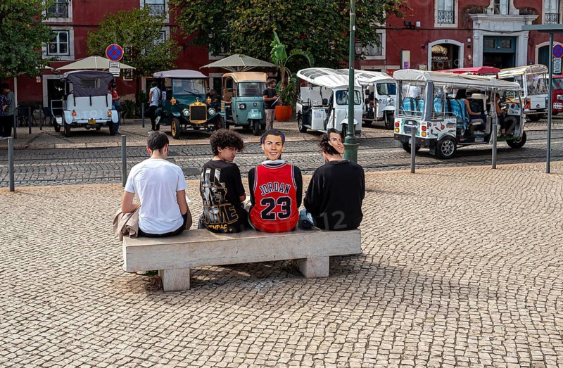 Street art, young people with Ronaldo mask on the back of their heads taking part in a school project about drawing, Lisbon, Portugal
