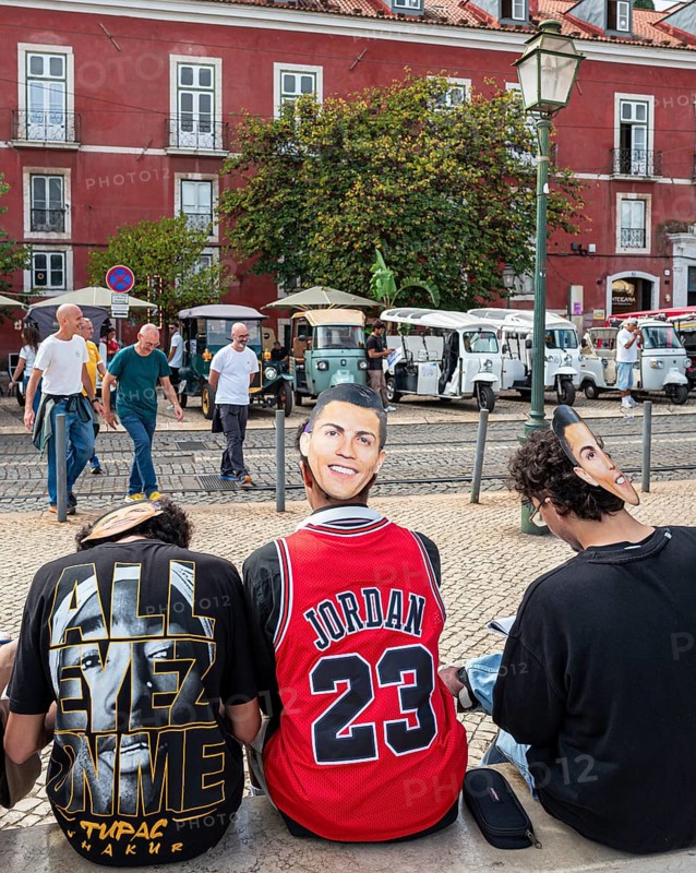 Street art, young people with Ronaldo mask on the back of their heads taking part in a school project about drawing, Lisbon, Portugal