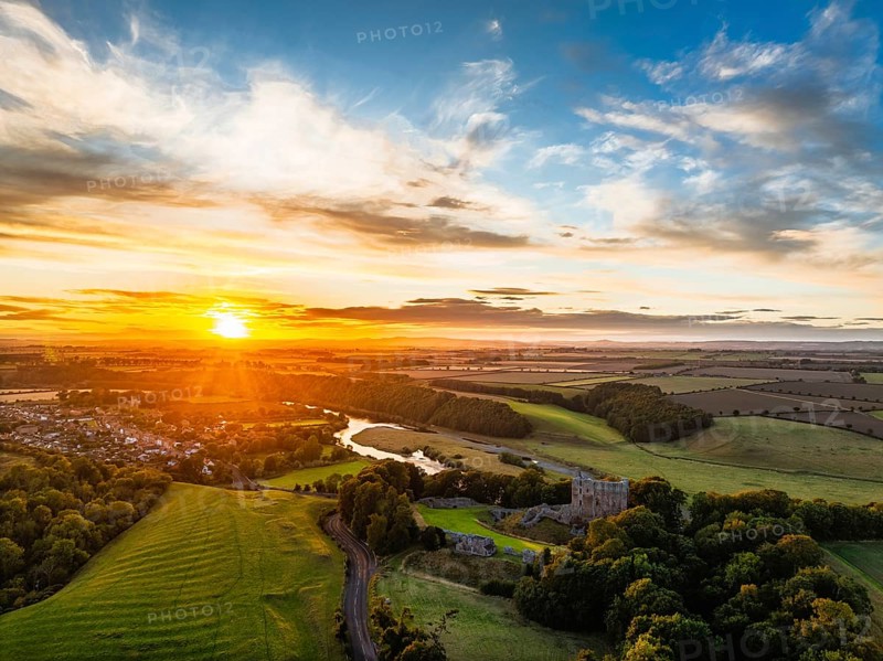 Sunset over Norham Castle and River Tweed from a drone, Norham, Northumberland, England, United Kingdom