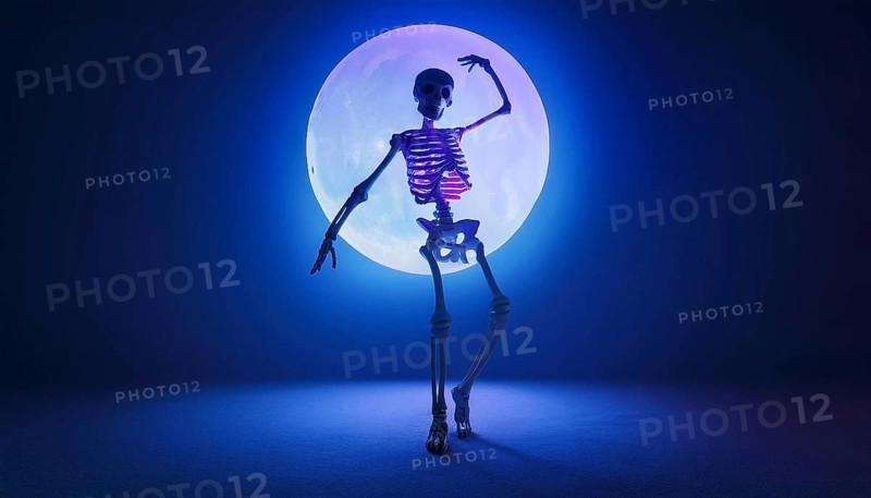 A skeleton stands in a dramatic pose with glowing bones, illuminated by a full moon. The scene, bathed in eerie blue light, creates a spooky and mysterious Halloween atmosphere, AI generated