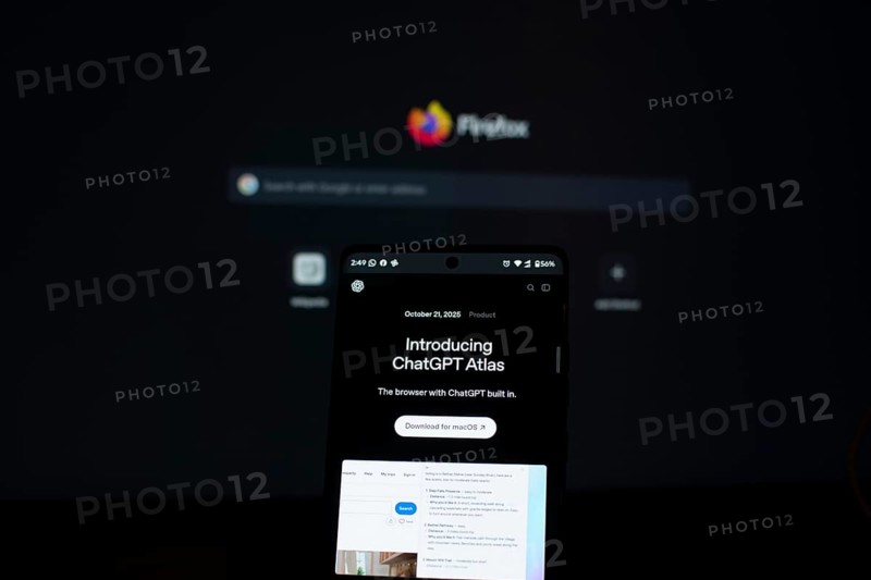 ChatGPT Atlas displayed on a smartphone with a Firefox screen in the background