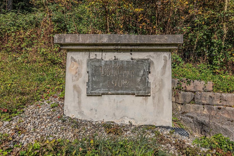 Water reservoir with the inscription Böttstein 1902 of the artificially created water channel that used to drive the historic oil mill and sawmill in Böttstein. Böttstein, Aargau, Switzerland