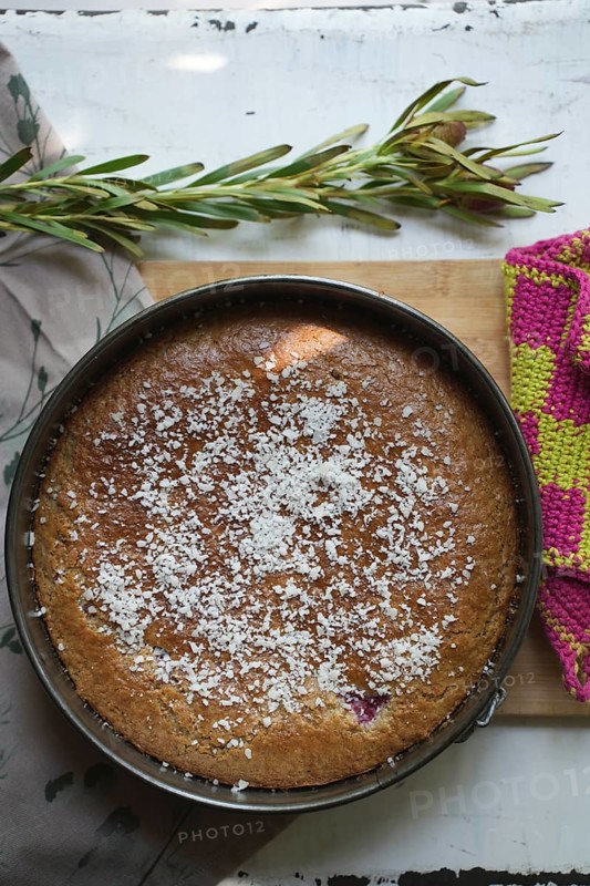 Coconut cake in an antique baking dish on a wooden board