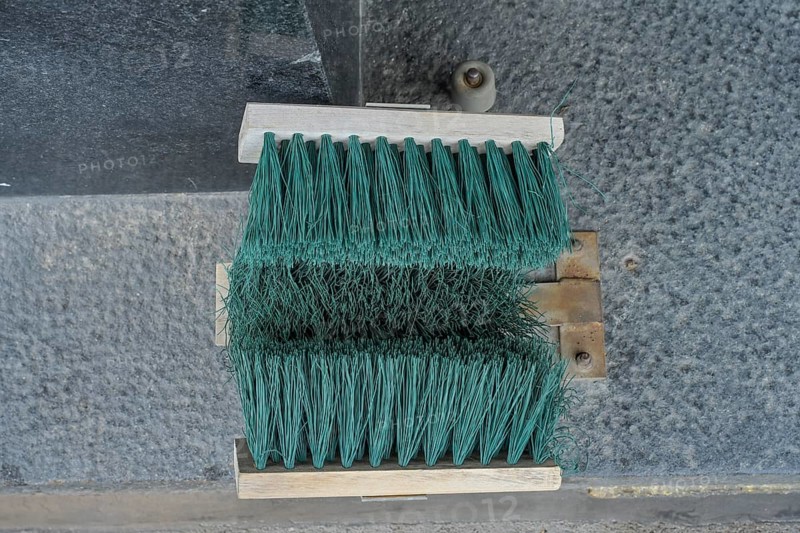 Broom at the entrance to the house, device for cleaning shoes in winter, Helsinki, Finland