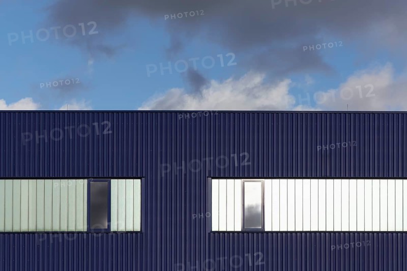 Blue corrugated iron façade with windows, blue sky, graphic, warehouse, logistics hall