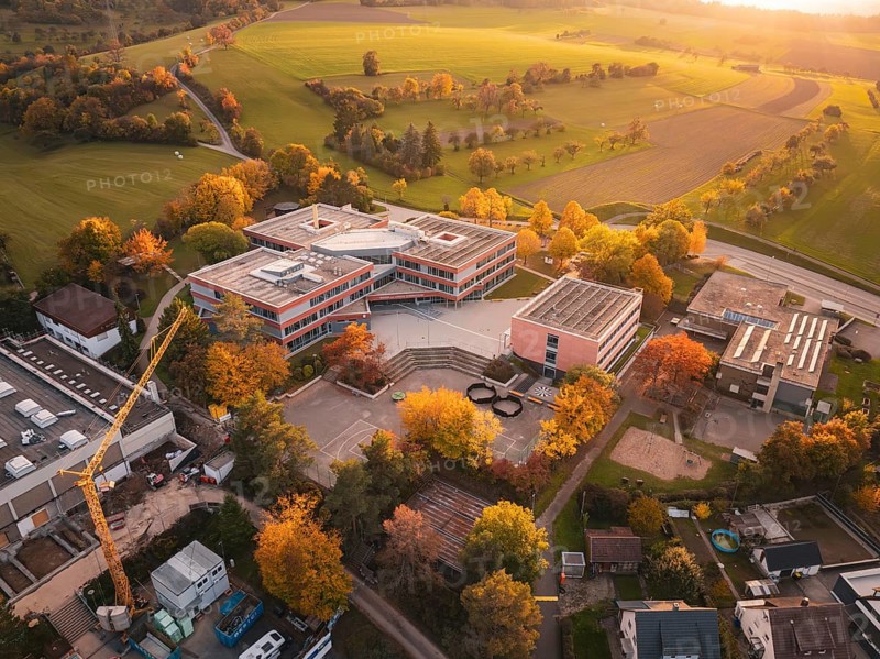 Modern Maria von Linden Gymnasium school building in autumn landscape at sunset, captured by drone, Calw, Black Forest, Germany