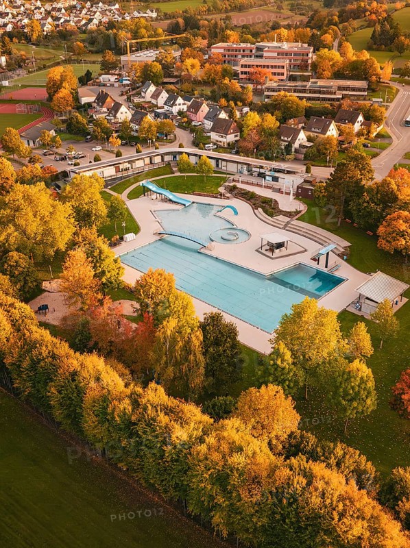 Aerial view of an outdoor pool in an autumn setting with colorful trees, Calw, Black Forest, Germany