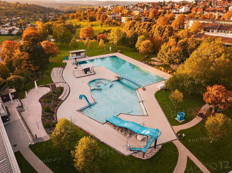 Outdoor pool with empty pool under autumn trees and hilly landscape, Calw, Black Forest, Germany