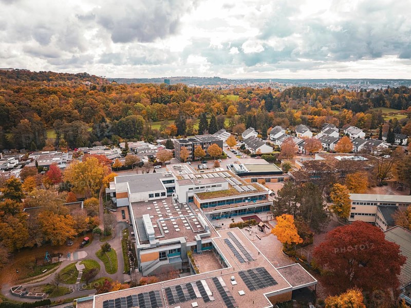 School building surrounded from above by autumn-colored trees and thick forest, Sindelfingen, Böblingen district, Germany