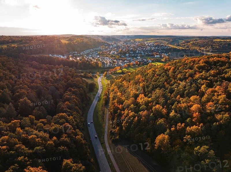 Autumn forest landscape with a road leading to a small settlement, Aidlingen, Böblingen district, Germany