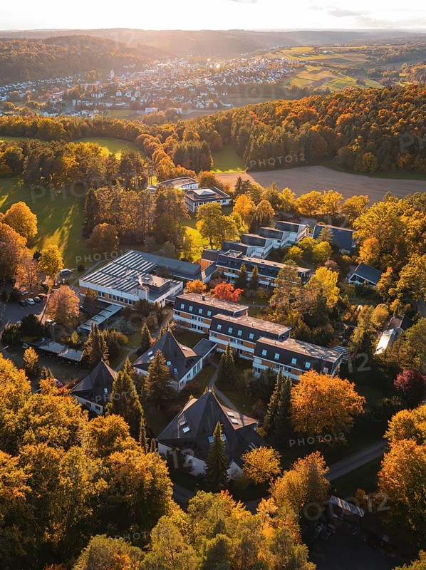 Sunlight illuminates motherhouse buildings and autumn trees in rural surroundings, Aidlingen, Böblingen district, Germany