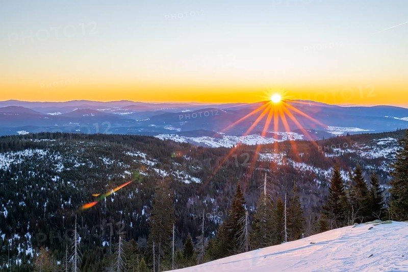 Sunrise over the hills of czech republic from Mount Lusen wth the view over the hills of the bavarian forest in winter, Bavaria, Germany