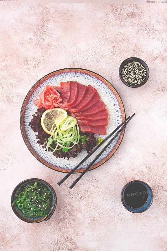 Freshly prepared sashimi with vibrant garnishes served on a decorative plate