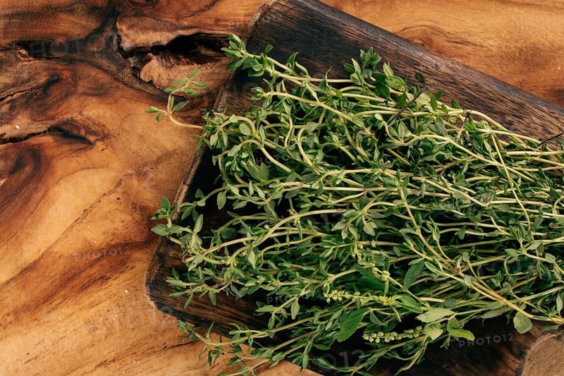 Fresh thyme sprigs on wooden cutting board ready for cooking and seasoning dishes
