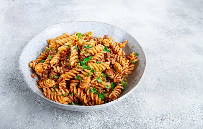 Pasta in navy, pasta with minced meat, gray background, homemade, fusilli pasta, no people