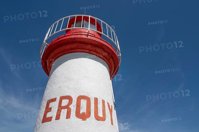 An extreme bottom view shows the upper, cylindrical part of the white-red lighthouse of Erquy, whose name is written in large, orange block letters on the tower shaft, against a bright blue sky, Erquy, Cap d'Erquy, Côtes-d'Armor department, Brittany region, France