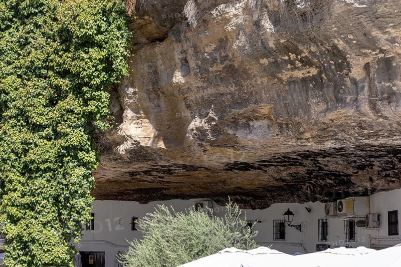 On the road to the white villages. Paths and narrow streets of a historic old town with many white houses were built around and in the mountain. Setenil de las Bodegas, Cadiz, Andalusia, Spain