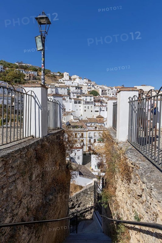 On the road to the white villages. Panorama or skyline of a historic old town with many white houses built on and in the mountain. Setenil de las Bodegas, Andalusia, Spain